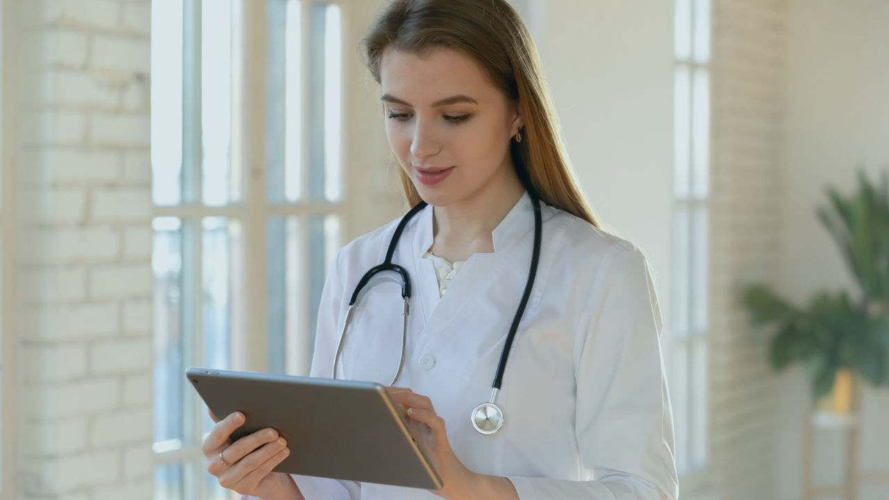 Médica segurando tablet. Imagem representa que a profissional está fazendo uma receita digital.