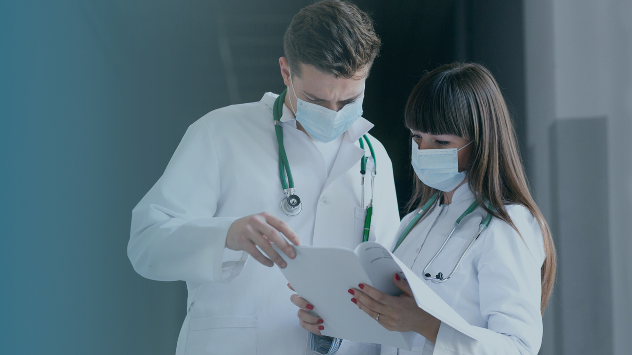 Dois médicos conversando. Imagem simboliza que estão falando sobre erros médicos que podem afetar o faturamento.