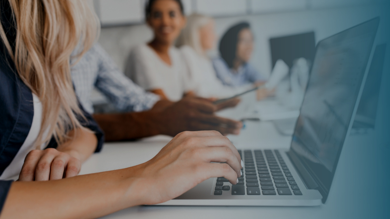 Equipe trabalhando em frente ao computador. Imagem simboliza funcionários da operadora trabalhado com o Monitoramento TISS.