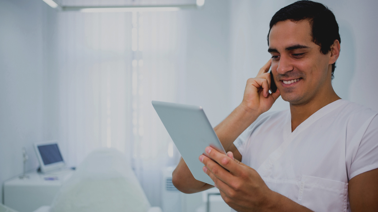 Médico com tablet na mão. Imagem simboliza que o médico está trabalhando com as guias médicas digitais.