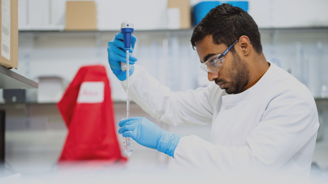 Profissional trabalhando em laboratório. Imagem representa que ele está trabalhando para melhorar a gestão financeira do laboratório.