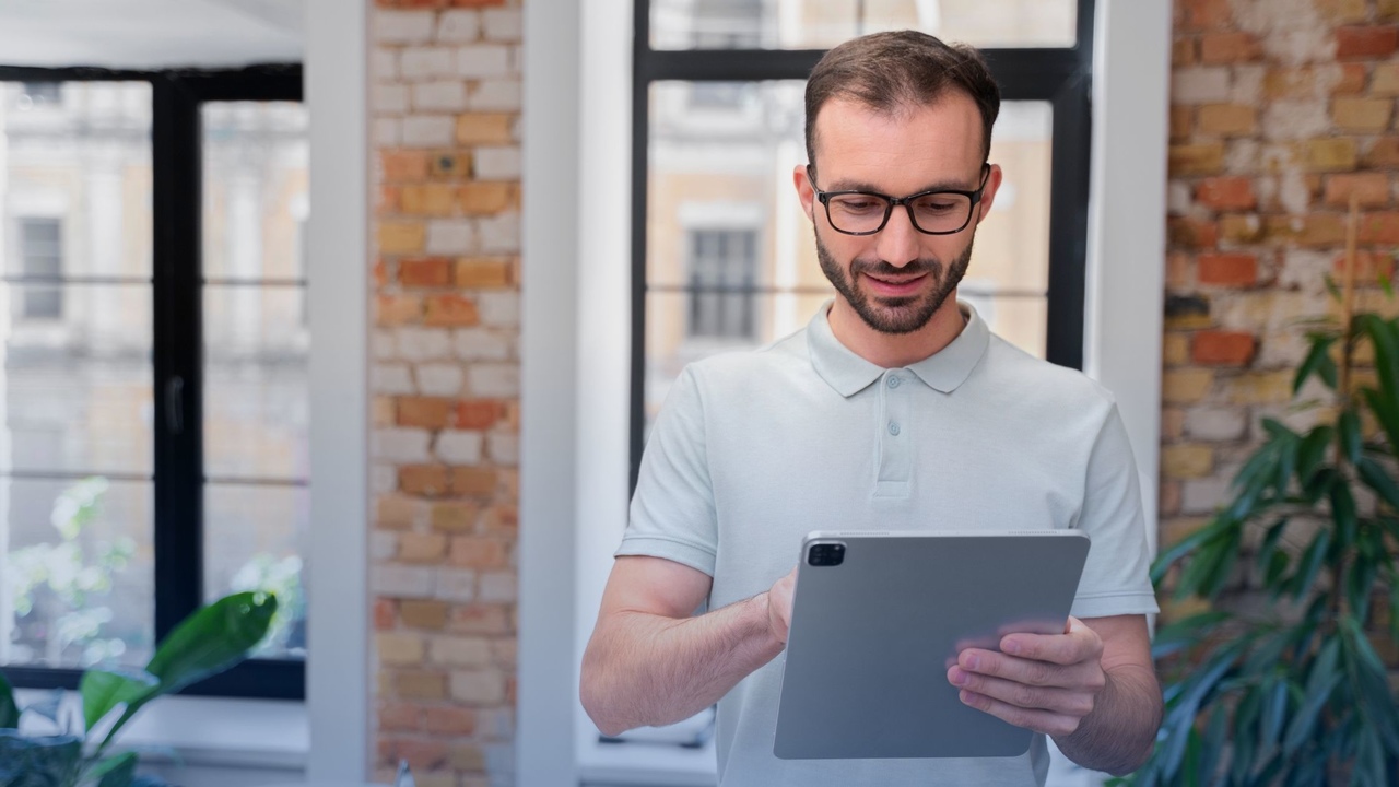 Profissional segurando tablet. Imagem simboliza que ele está lendo o artigo: Quais informações da guia TISS analisar antes de faturar?